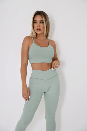 woman wearing mint sports bra and standing
